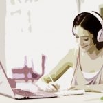 Portrait of a student learning on line with headphones and laptop taking notes in a notebook sitting at her desk at home